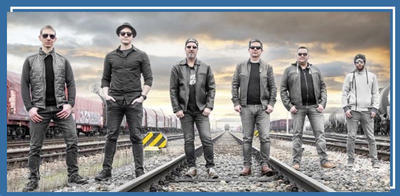 Sechs männliche Bandmitglieder stehen auf Gleisen
