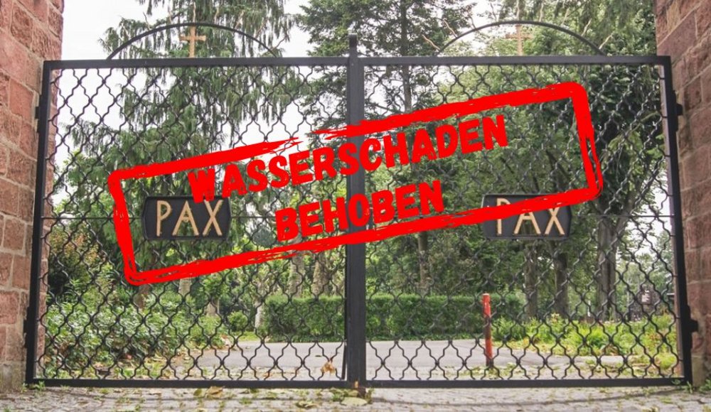 Ein geschlossenes, schwarzes, schmiedeeisernes Eingangstor eines Friedhofs zwischen zwei Sandsteinmauern. Auf beiden Torflügeln befindet sich jeweils eine schwarze Tafel mit der goldfarbenen Aufschrift „PAX“. Hinter dem Tor sind ein Weg, grüne Sträucher und hohe Bäume zu sehen. Quer über das Tor ist ein großer, leicht schräg stehender roter Stempel mit der Aufschrift „WASSERSCHADEN BEHOBEN“ eingeblendet.