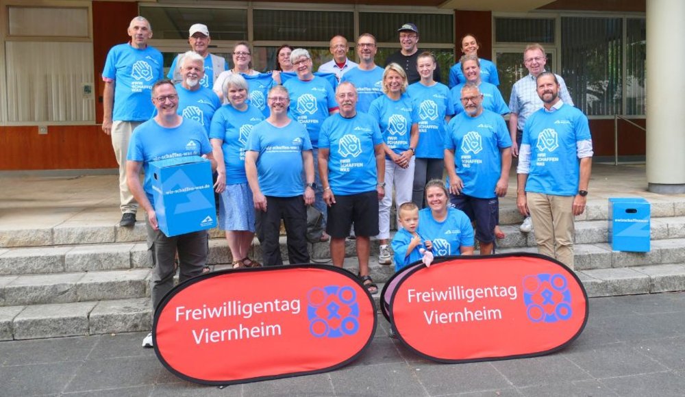Gemeinsam für die Freiwilligentage: Bürgermeister Matthias Baaß (2. Reihe, r.), Harald Hofmann (vorne l.), Kirsten Korte (1. Reihe, 4. v. r.) und Dani Marquardt (vorne r.) mit Vertreterinnen und Vertretern der teilnehmenden Projekte. Beim Pressetermin wurden auch die „Wir-schaffen-was“-Helfer-Shirts für den Aktionstag am 19. September verteilt.